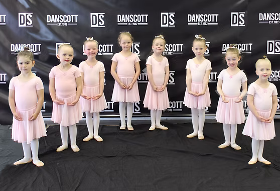 Young Danscott ballet dancers in pink standing together in front of the studio backdrop